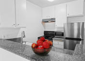 Thumbnail 2 of 48 - a kitchen with stainless steel appliances and a bowl of apples