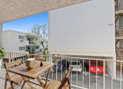 Thumbnail 4 of 48 - a balcony with a table and chairs and a parking lot