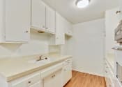 Thumbnail 7 of 14 - Kitchen with White kitchen cabinets and cupboards, Double white kitchen sink and Tile countertops on the right side, White Oven on the left side