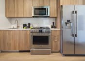 Thumbnail 5 of 12 - a kitchen with stainless steel appliances and wooden cabinets