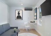 Thumbnail 7 of 16 - a living room with a blue couch and a table