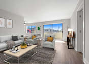 Thumbnail 3 of 22 - A living room with a grey sofa, a yellow coffee table, and a grey armchair.