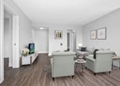 Thumbnail 6 of 22 - A living room with a grey couch and a white coffee table.