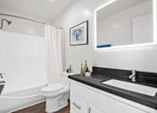 Thumbnail 19 of 22 - A white toilet sits next to a bathtub in a bathroom.