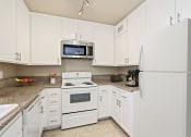 Thumbnail 1 of 11 - a kitchen with white appliances and white cabinets