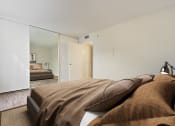 Thumbnail 8 of 11 - a bedroom with white walls and a large bed with brown pillows