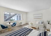 Thumbnail 3 of 83 - A living room with a white couch, blue chairs, and a painting on the wall.