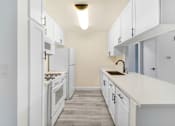 Thumbnail 19 of 91 - A kitchen with white cabinets and appliances.