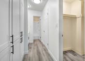 Thumbnail 23 of 91 - A hallway with white cabinets and a light brown floor.