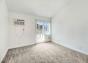 Thumbnail 25 of 91 - A room with a window covered by blinds and a wall-mounted air conditioner unit.