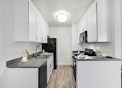 Thumbnail 1 of 95 - A kitchen with black appliances and white cabinets.