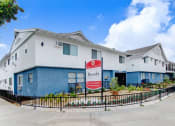 Thumbnail 54 of 83 - a white and blue building with a red and white sign in front of it
