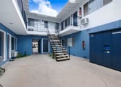 Thumbnail 53 of 83 - a stairway leading up to a white and blue building with a blue garage door