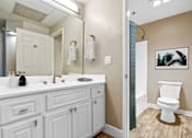 Thumbnail 8 of 26 - A bathroom with a white toilet and a white sink.