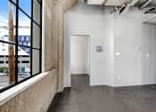 Thumbnail 77 of 92 - a large window in a room with concrete floors and a door at the end of the room
