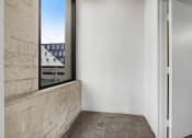Thumbnail 73 of 92 - a bedroom with a large window and a concrete wall