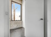 Thumbnail 74 of 92 - a white door with a window in a room with concrete floors and a brick wall