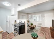 Thumbnail 3 of 28 - an open kitchen and living room with a dining table and a refrigerator