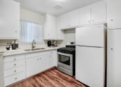 Thumbnail 10 of 28 - the preserve at ballantyne commons apartment kitchen with white cabinets and stainless steel appliances