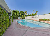 Thumbnail 55 of 55 - A pool surrounded by greenery and a white wall with a sign on it.