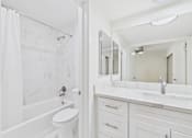 Thumbnail 25 of 65 - A white bathroom with a toilet, sink, and shower.