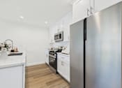 Thumbnail 22 of 65 - A modern kitchen with a refrigerator on the right.