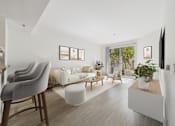 Thumbnail 10 of 41 - A living room with a grey chair and a white sofa.