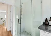 Thumbnail 16 of 28 - A bathroom with a glass shower door and a white cabinet.