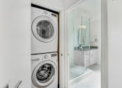Thumbnail 14 of 28 - A white washing machine and dryer in a laundry room.