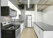Thumbnail 27 of 92 - an empty kitchen with white cabinets and stainless steel appliances