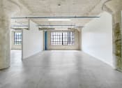 Thumbnail 44 of 92 - an empty room with a large window and concrete floors and walls