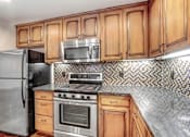 Thumbnail 23 of 88 - a kitchen with wooden cabinets and stainless steel appliances