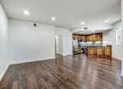 Thumbnail 69 of 88 - a kitchen and living room with hardwood floors and white walls