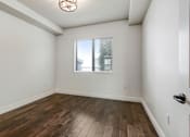 Thumbnail 74 of 88 - a bedroom with hardwood floors and a large window