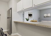 Thumbnail 13 of 65 - A kitchen with a stainless steel refrigerator and white cabinets.