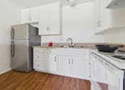 Thumbnail 3 of 46 - A kitchen with white cabinets and a stainless steel refrigerator.