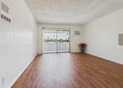 Thumbnail 4 of 46 - A room with a wooden floor and a sliding glass door.