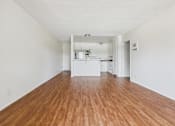 Thumbnail 6 of 46 - A long, empty room with wooden floors and white walls.
