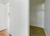 Thumbnail 10 of 46 - A room with a white wall and a wooden floor.