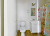 Thumbnail 11 of 46 - A white toilet sits next to a white sink in a small bathroom.