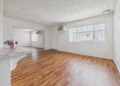 Thumbnail 33 of 46 - A room with wooden floors and a white countertop with flowers on it.
