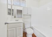 Thumbnail 34 of 46 - A white bathroom with a toilet, sink, and bathtub.