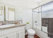 Thumbnail 21 of 46 - A white toilet sits next to a sink in a bathroom.