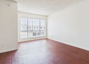 Thumbnail 14 of 46 - Empty room with wooden floor and white walls.