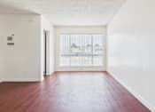 Thumbnail 18 of 46 - A room with a wooden floor and a window with blinds.
