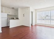 Thumbnail 17 of 46 - A kitchen with white appliances and wooden floors.