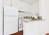 Thumbnail 12 of 46 - A white refrigerator stands in a kitchen with a marble countertop.