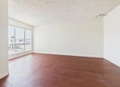 Thumbnail 13 of 46 - A room with a wooden floor and a window.