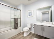 Thumbnail 32 of 42 - Bathroom With hot tub and shower combo, single vanity, wood style flooring, Brand New Apartment Rentals Near Sherman Oaks