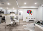Thumbnail 21 of 42 - Luxurious interior of a unit, living room in the right, dining area, Open kitchen on the left with stainless steel appliances, laminate flooring throughout, recessed lighting